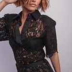 Fashion model with wavy, shoulder-length hair in a black lace dress.